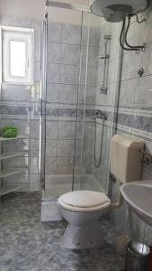 博扎瓦Apartments Irena的带淋浴、卫生间和盥洗盆的浴室