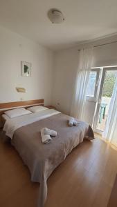 博扎瓦Apartments Irena的一间卧室配有一张大床和毛巾