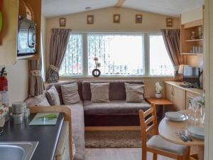 伯克顿Norfolk Lavender Caravan - Sleeps 4 - WiFi and Sky TV Included的客厅配有沙发和桌子
