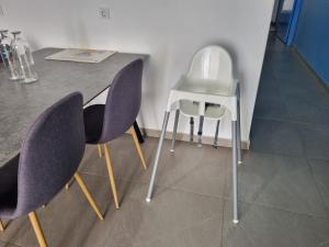 普拉亚Appartement Cara do Mar的一张桌子、紫色椅子和白色凳子