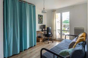 贝桑松Appartement très calme, terrasse & jardin en ville的客厅配有蓝色窗帘和书桌