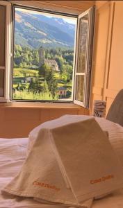 罗丁Casa Dorino - Casa di vacanza ideale per famiglie的一张带山景窗户的床