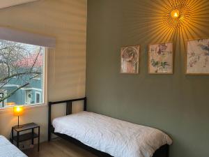 阿尔梅勒Lovely family house nearby Amsterdam and Schiphol的一间卧室设有两张床、一个窗口和一盏灯。