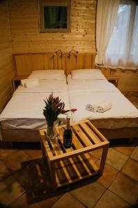 Osiek迪瓦尔酒店的一间卧室设有两张床和一张桌子,并提供一瓶葡萄酒