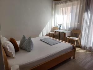 萨洛尔诺Albergo Gasthof Salurn的一间卧室配有一张床和一张桌子及窗户