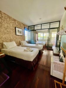 清迈UDEE Cozy Hotel的酒店客房设有两张床和窗户。