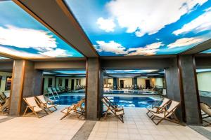 班斯科Gardenia Park Hotel的一个带椅子和天空壁画的游泳池