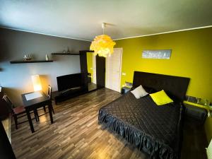奥拉迪亚Prima Residence Apartment的一间卧室设有一张床和黄色的墙壁