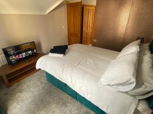LisnaskeaDerryree House的卧室配有一张大白色床和平面电视