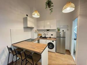 马德里HomeStay Lopez Pando的厨房配有桌椅和冰箱。