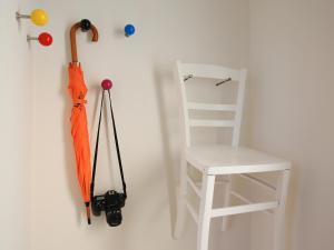 罗拉赫apartment-S Sonnenrain的挂在白色椅子旁边的墙上的橙色伞