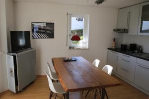 罗拉赫apartment-S Sonnenrain的厨房配有木桌和白色椅子