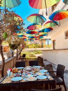 乌奇希萨尔Aysultan Stone House的一张桌子,上面放着食物盘和五颜六色的雨伞