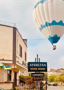 乌奇希萨尔Aysultan Stone House的热气球在商店上空飞行
