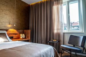 斯普利特Calma Luxury Rooms的卧室配有床、椅子和窗户。