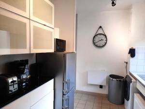 坎佩尔Ty Cocoon- Appartement avec terrasse et parking privé的厨房配有冰箱和墙上的时钟