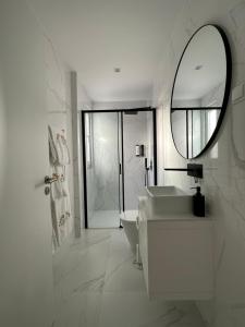 里斯本Ajuda Luxury Appartments的白色的浴室设有水槽和镜子