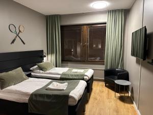 谢莱夫特奥Hotel B&B Gränden的酒店客房设有两张床和窗户。