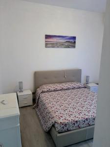 加比切马莱Residence Vigna del Mare的卧室配有一张床,墙上挂着一幅画