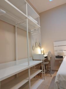 斯普利特Apartment Vespa & Jacuzzi的一间卧室配有一张床、一张桌子和一张床,另一间卧室配有