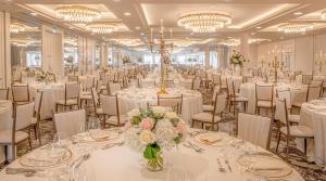圣安德鲁斯圣安德鲁斯老球场酒店的宴会厅配有白色的桌椅和吊灯