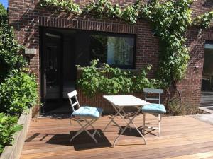 鲁汶'het T-huisje' volledig ingerichte studio的木甲板上的一张桌子和两把椅子
