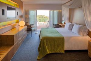 阿尔布费拉阿尔加维史诗萨纳酒店的酒店客房设有一张大床和一台电视。