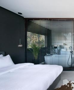 海法Urbanica Carmel- Apartments的卧室设有白色的床和大窗户