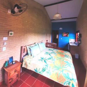 Divino de São LourençoEspaço Puri的一间卧室设有一张床和砖墙