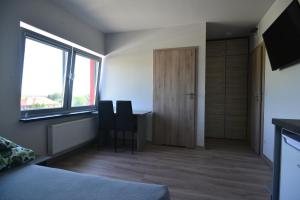 SufczynNoclegi URAN的一间卧室配有书桌、两把椅子和窗户。