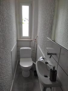 VeitsbronnGästezimmer Boxenstopp的白色的浴室设有卫生间和水槽。