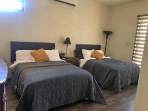 埃莫西约Hermosa residencia de lujo的一间卧室配有两张床和一盏灯