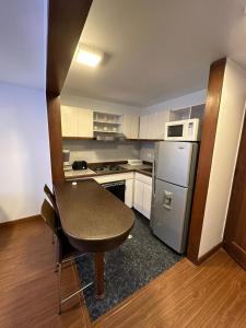 波哥大Cómodo Apartaestudio en super ubicación的一间带桌子和冰箱的小厨房
