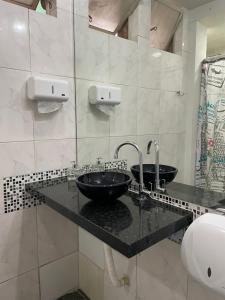 贝洛奥里藏特达奥尔拉潘姆普拉旅舍的浴室设有黑色柜台上的两个盥洗盆