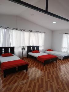 金巴亚Finca Hotel el Guadual的铺有木地板的客房内的两张床