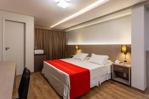 弗洛里亚诺波利斯法洛尔达伊拉酒店的一间卧室配有一张带红色毯子的大床