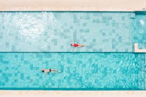 蓬塔卡纳Live Aqua Punta Cana - All Inclusive - Adults Only的两人在大型游泳池游泳