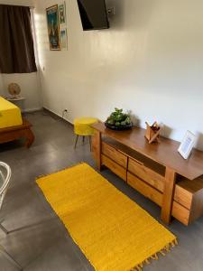 帕皮提Bungalow APETAHI的客厅配有桌子和黄色地毯