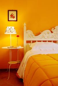 阿韦利诺Le Stanze dei Nonni的黄色的卧室配有一张床和一张带台灯的桌子