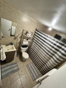 华雷斯城Departamento, recién remodelado a 3 min USA. 2的浴室配有淋浴帘、卫生间和盥洗盆。