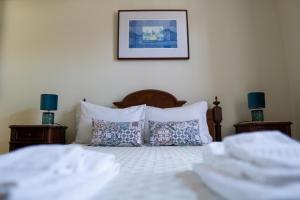 孔迪镇Casa Mindela Farmhouse的一间卧室配有带白色床单和枕头的床。
