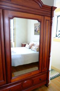 孔迪镇Casa Mindela Farmhouse的一间卧室配有木制橱柜内的大镜子