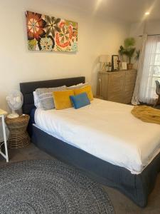 LyndhurstAnge's BnB - Self Contained Unit with Ensuite的一间卧室配有一张大床,提供黄色和蓝色的枕头