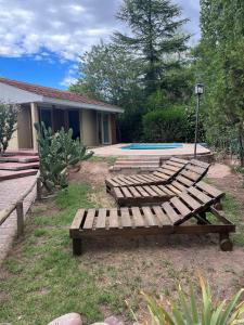 卢汉德库约Casa en Chacras de Coria - zona de Bodegas的坐在院子中的一组木凳