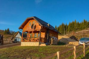 ZaovineTarovuk cabin的山丘上一座带黑色屋顶的木屋
