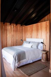 何塞伊格纳西奥Aires Puros的卧室配有白色的木墙床