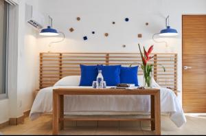 阿卡普尔科Hotel Casa de sal的一间卧室配有一张带蓝色枕头的床和一张桌子