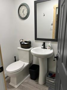 丘吉尔Bears Den Guest House II的一间带卫生间、水槽和时钟的浴室