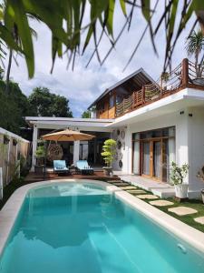 吉利阿尔Rumah Tara Modern 3 bedroom pool and garden villa in Gili Air的房屋前有游泳池的房子