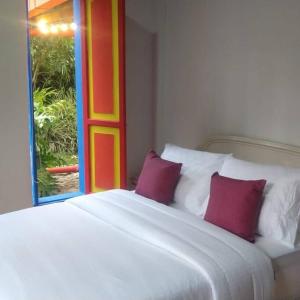 VillamaríaCASA DE CAMPO VILLA OLI!! - Un paraiso natural en la ciudad的一张带两个红色枕头的白色床和窗户